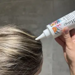 Aplikacja peelingu do skóry głowy z kwasami AHA na wilgotne włosy. Produkt w białej tubce z kolorowymi owocami.