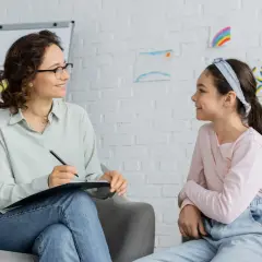 Terapeuta rozmawia z dzieckiem, wspierając je w zrozumieniu spektrum autyzmu i zespołu Aspergera.