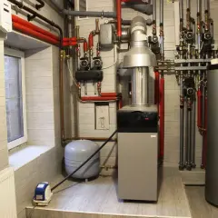 Nowoczesna instalacja ogrzewania centralnego z kotłem, zasobnikiem i pompą obiegową.