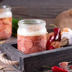 Słoiki z mięsem, idealne do sosu do spaghetti. Obok cebula, czosnek i papryczki chili. Czy można zawekować sos do spaghetti z mięsem? Tak!