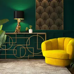 Elegancja w stylu sztuka art deco: złoty kot-lampa, żółty fotel i geometryczne zdobienia na tle butelkowej zieleni.