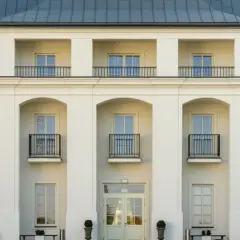 Elegancki Zamek Janów Podlaski, z białymi fasadami i ciemnym dachem, zachęca do odwiedzin. Opinie gości potwierdzają jego urok.