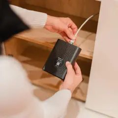 Man conectando un cable a un **home gateway** negro dentro de un mueble de madera.