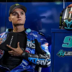 Adrian Huertas, piloto de motociclismo, con su casco y mono azul. El número 99 destaca en el fondo.