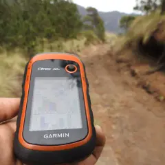 Ręka trzyma GPS Garmin Etrex 20x, idealny do poszukiwań w terenie. To właśnie dzięki takim urządzeniom odkrywasz, geocaching co to jest i jak działa.