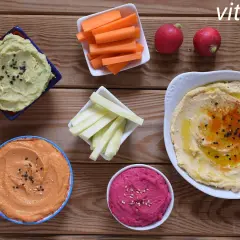 Variedad de hummus, zanahorias, apio y rábanos. Ideas para recetas de hummus saludables y deliciosas.