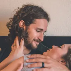 Coppia in intimità, lui la guarda con amore, lei appoggia la testa sul suo petto. Mio marito vuole fare l'amore tutti i giorni, e momenti così lo confermano.