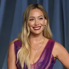 Hilary Duff, bekannt für ihre Filme und Serien, strahlt in einem lila Kleid.