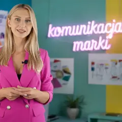 Kobieta w różowej marynarce wyjaśnia, jak przygotować się do pracy w branży marketingowej. W tle neon "komunikacja marki".