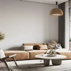 Salon w stylu wabi sabi: beżowa kanapa, pleciony fotel, suszone trawy i palma.