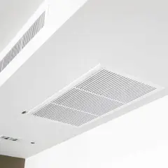 Sufit z kratkami wentylacyjnymi, w tym duży prostokątny element i długi węższy, świadczą o sprawnie działającej klimatyzacji kanałowej.
