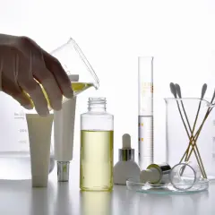 Mano con guanto versa liquido giallo in provetta. Si teme che la gomma xantana faccia male.