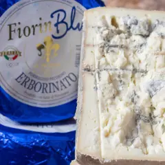 Fiorin Blu, un formaggio con muffa nome Erborinato, mostra venature blu e verdi su una pasta bianca e friabile.