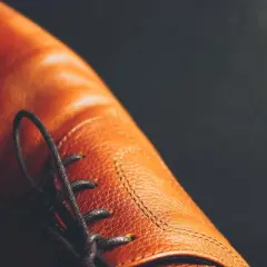 Gros plan sur une chaussure en cuir marron, avec ses lacets noirs. Une question se pose : peut on teindre des chaussures en cuir pour changer leur couleur ?