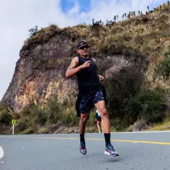 Mężczyzna biegnie pod górę, pokonując trasę biegu na 10 km. Jaki czas jest dobry? Zależy od kondycji, ale ten zawodnik wygląda na zdeterminowanego.