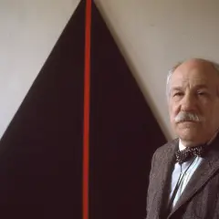 John Plaster poses in front of a striking abstract painting, possibly at the Guggenheim.
