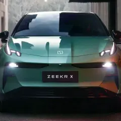 El elegante Zeekr X verde se detiene en una calle urbana, sus luces LED brillan intensamente.