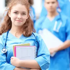 Młoda lekarka w niebieskim uniformie ze stetoskopem i notatkami.