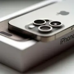 Nowy iPhone 15 na pudełku. Zbliżenie na moduł aparatów i logo Apple. Poznaj jego wymiary.