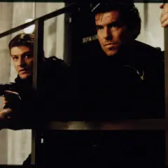 Pierce Brosnan och en kollega i actionfyllda filmer. De är redo för strid med vapen i hand.