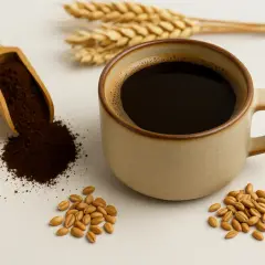 Ziarna pszenicy, drewniana łyżka z kawą zbożową i filiżanka napoju. To najlepsza kawa zbożowa, pełna smaku i aromatu.
