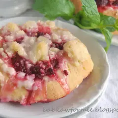 Pyszne drożdżówki z malinami, posypane kruszonką i polane lukrem, kuszą swoim wyglądem.