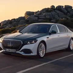 Elegancki, dwukolorowy Maybach, uznawany za najbardziej luksusowy samochód na świecie, sunie po górskiej drodze o zachodzie słońca.