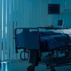 Zmartwiona matka siedzi przy łóżku chorej córki w szpitalu. Scena sugeruje zespół Münchhausena u matek, gdzie matka może wywoływać objawy u dziecka.