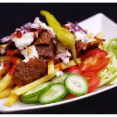 En tallrik med kebab, pommes frites, tomater, gurka, sallad och en stark chili. Perfekt för dig som söker ett gott kebabsås recept.