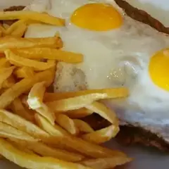 Un delicioso plato de milanesa a caballo, con dos huevos fritos y papas fritas crujientes.