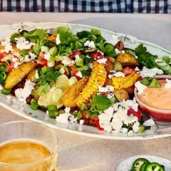 En härlig sallad med rostad majs, fetaost, tomater, koriander och lime. Serveras med en krämig dipp.