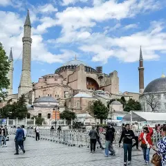 Tłum ludzi spaceruje przed majestatyczną Hagia Sophia w Stambule, podziwiając jej architekturę.