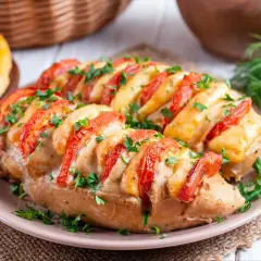 Pyszny filet z kurczaka na obiad inaczej, zapieczony z pomidorami i serem, posypany natką pietruszki.
