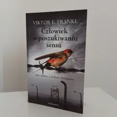 Okładka książki "Człowiek w poszukiwaniu sensu" Viktora Frankla. Ptak siedzi na drutach kolczastych, symbolizując nadzieję w mrocznych czasach.