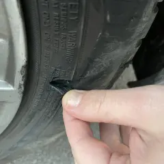 Un pneu abîmé sur le flanc, probablement suite à un choc contre le trottoir. La gomme est déchirée.