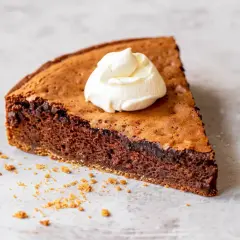En bit chokladkaka med proteinpulver, toppad med vispad grädde. Perfekt för den som vill baka med proteinpulver.