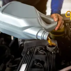 Mechanik wlewa olej do silnika. Dowiedz się, ile kosztuje wymiana oleju i filtrów robocizna.