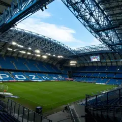 Pusta, błękitna arena z zieloną murawą i napisem "POZNAŃ" na trybunach. Pojemność stadionu Lecha Poznań robi wrażenie.