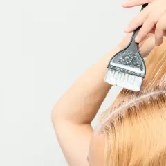 Persona se aplica tinta en el cabello, un proceso de tinta en casa para un cambio de look.