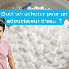 Un homme joyeux montre un seau rempli de pastilles de sel régénérant, expliquant à quoi sert le sel régénérant pour adoucir l'eau.