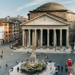 La Piazza della Rotonda à Rome, avec le majestueux Panthéon et sa fontaine. Des passants profitent de la journée ensoleillée.