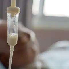 Kroplówka z płynem odżywczym, być może cernevit, podawana pacjentowi w szpitalu.