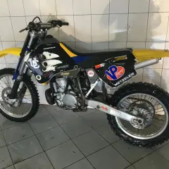 Husqvarna WR 250, gotowy do akcji. Czarne plastiki z żółtymi i niebieskimi akcentami, opony Metzeler.