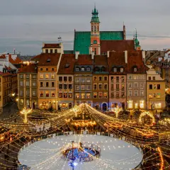 Magiczny zimowy wieczór w Warszawie. Rynek Starego Miasta rozświetlony tysiącami lampek, lodowisko i choinka tworzą idealną atmosferę na city break w Polsce.