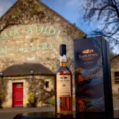 Bouteille de whisky Blair Athol 20 ans et sa boîte devant la distillerie.