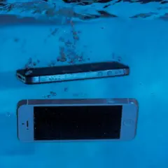 Dwa smartfony, jeden srebrny, drugi czarny, zanurzają się w wodzie. Ten wodoodporny smartfon przetrwa nawet takie zanurzenie.
