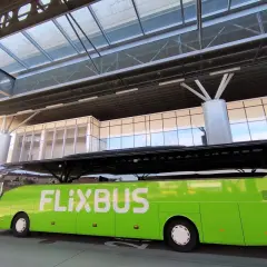 Zielony autobus FlixBus czeka na pasażerów na nowoczesnym dworcu. To idealne miejsce na rozpoczęcie podróży, bo flixbus przystanki są dobrze zorganizowane.