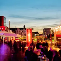 Menschenmassen beleben die Reeperbahn in der Woche, während das Reeperbahn Festival mit roten Bannern und Lichtern für Stimmung sorgt.