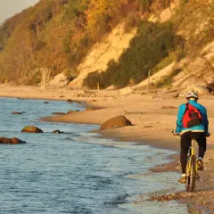 Rowerzysta na plaży, cieszący się piękną, jesienną pogodą na nadmorskiej trasie rowerowej Trójmiasto.