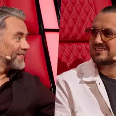 Dwóch mężczyzn siedzi na czerwonych fotelach. Jeden ma siwe włosy i brodę, drugi ma dredy i okulary.